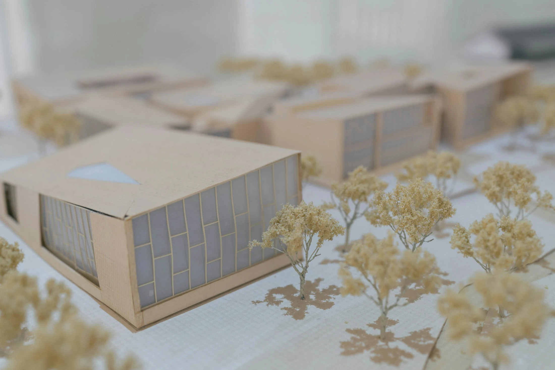 A physical architectural scale model on a studio table in soft natural light