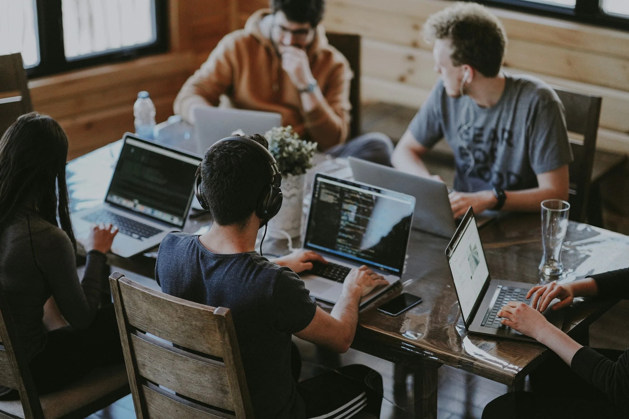 People collaborating on laptops in an informal shared workspace, used as editorial imagery